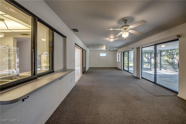 unfurnished room with ceiling fan and carpet flooring