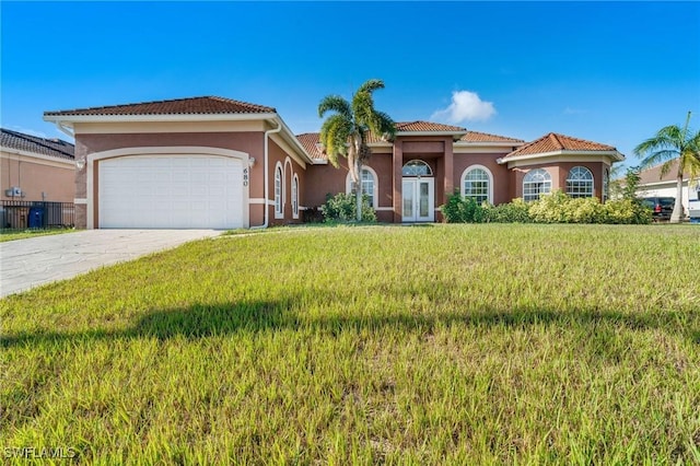 mediterranean / spanish-style home with a garage and a front yard