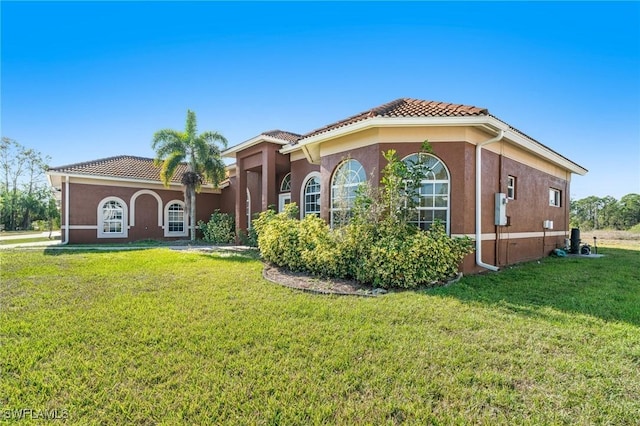 mediterranean / spanish house with a front lawn