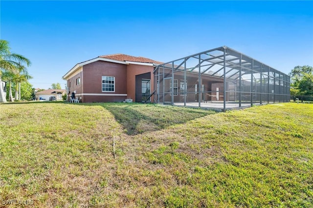 back of property featuring a yard, a lanai, and a patio