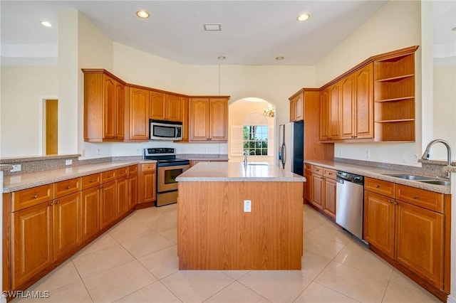 kitchen featuring light tile patterned flooring, sink, kitchen peninsula, a kitchen island, and stainless steel appliances