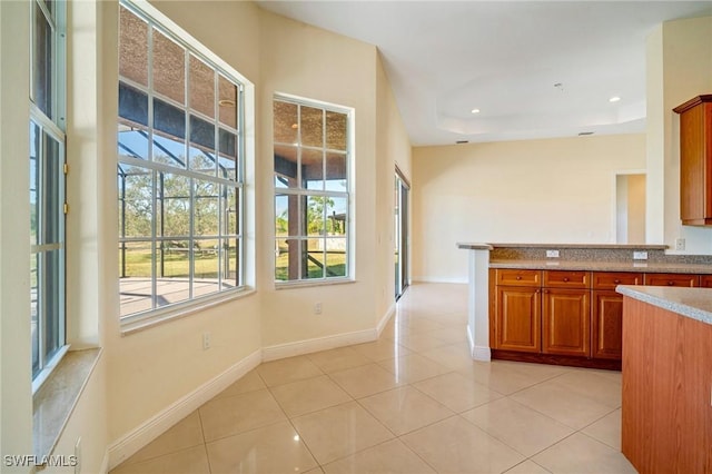 kitchen with a raised ceiling and light tile patterned floors