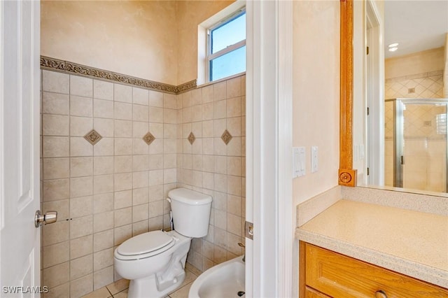 bathroom with tile walls, toilet, a shower with door, a bidet, and tile patterned floors