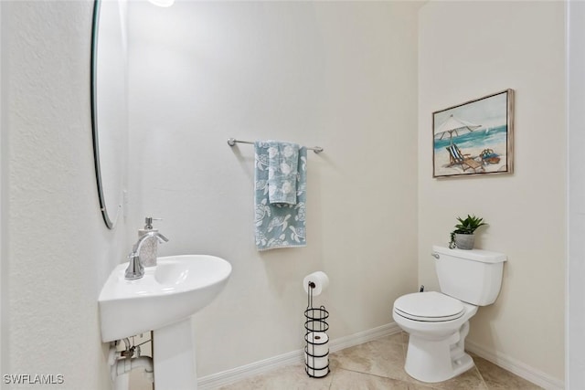 bathroom with tile patterned flooring, sink, and toilet