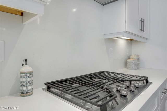 interior details featuring stainless steel gas cooktop and white cabinets