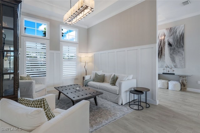 living room with crown molding and light hardwood / wood-style flooring