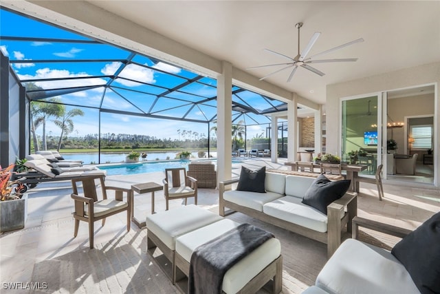 view of patio with a water view, ceiling fan, outdoor lounge area, and glass enclosure