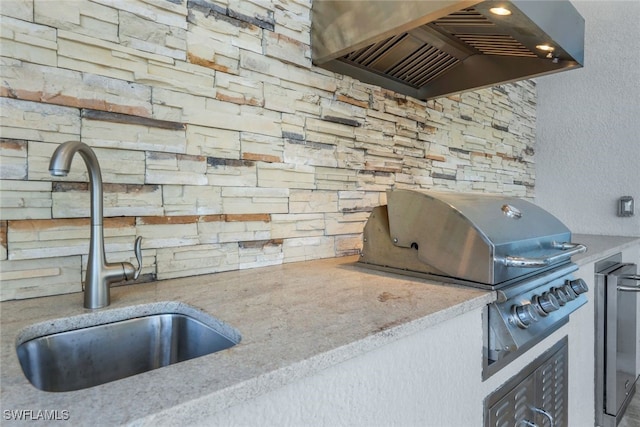 kitchen featuring wine cooler, sink, and wall chimney range hood