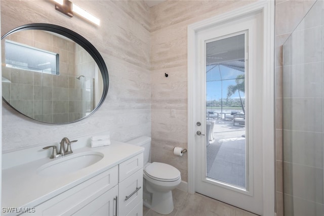 bathroom with vanity, tile walls, and toilet