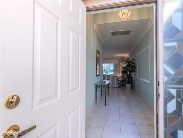 hall with light tile patterned flooring and crown molding