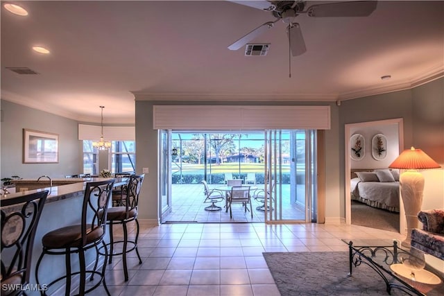 tiled living room with ceiling fan with notable chandelier and ornamental molding