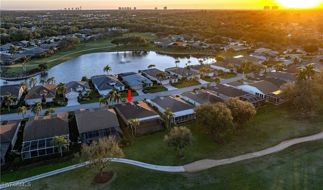 aerial view at dusk featuring a water view