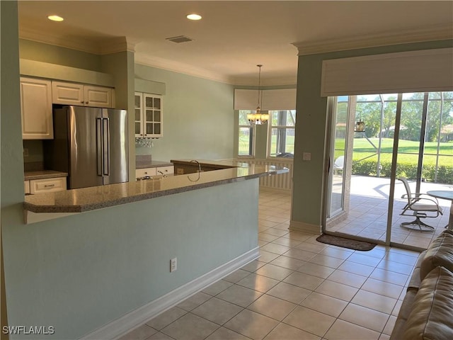 9269 Coach House Ln, Estero, FL 33928 - kitchen featuring visible vents, ornamental molding, light tile patterned flooring, high quality fridge, and decorative light fixtures