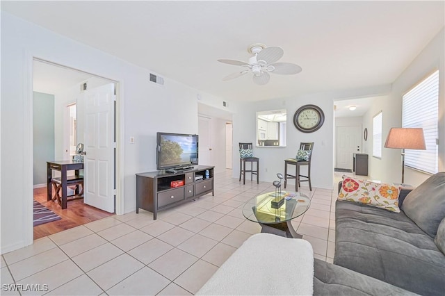 living room featuring light tile patterned floors and ceiling fan