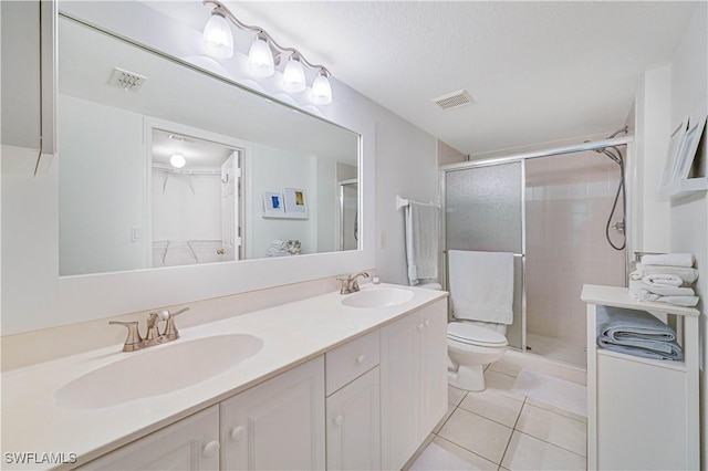 bathroom featuring vanity, toilet, an enclosed shower, and tile patterned flooring