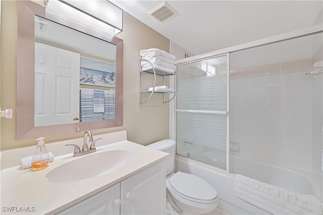 full bathroom featuring vanity, shower / bath combination with glass door, and toilet