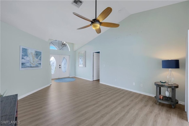 unfurnished living room featuring ceiling fan, high vaulted ceiling, light hardwood / wood-style floors, and french doors