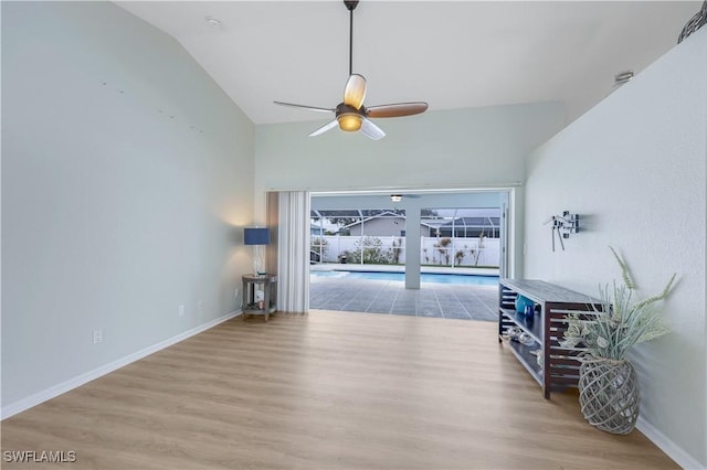 living room with ceiling fan, lofted ceiling, and light hardwood / wood-style floors