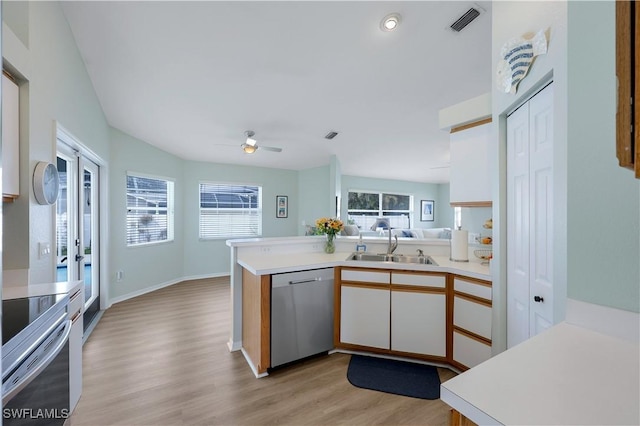 kitchen with appliances with stainless steel finishes, kitchen peninsula, sink, and white cabinets