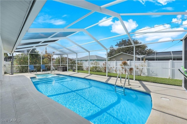 view of pool featuring an in ground hot tub, glass enclosure, and a patio area