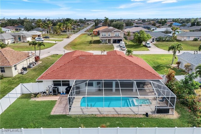 view of swimming pool with a patio, a lanai, and a lawn