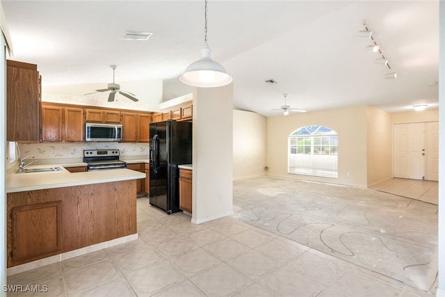 kitchen featuring appliances with stainless steel finishes, decorative light fixtures, lofted ceiling, sink, and kitchen peninsula