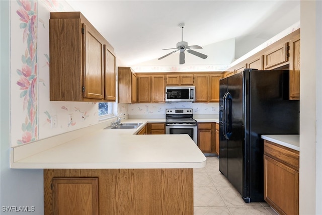 kitchen featuring lofted ceiling, sink, ceiling fan, kitchen peninsula, and stainless steel appliances