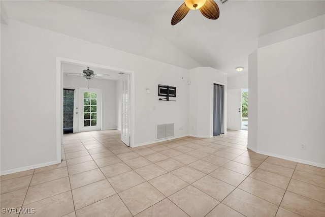 empty room featuring ceiling fan, lofted ceiling, and light tile patterned floors