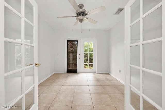 empty room featuring french doors, ceiling fan, and light tile patterned flooring