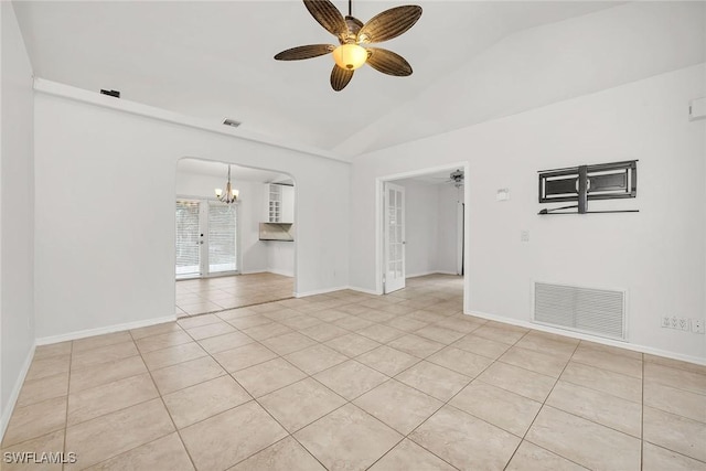 tiled spare room featuring lofted ceiling and ceiling fan with notable chandelier