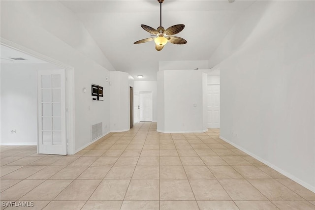 spare room with lofted ceiling, light tile patterned floors, and ceiling fan