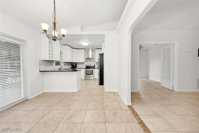 kitchen featuring white cabinetry, decorative light fixtures, light tile patterned floors, appliances with stainless steel finishes, and wall chimney range hood