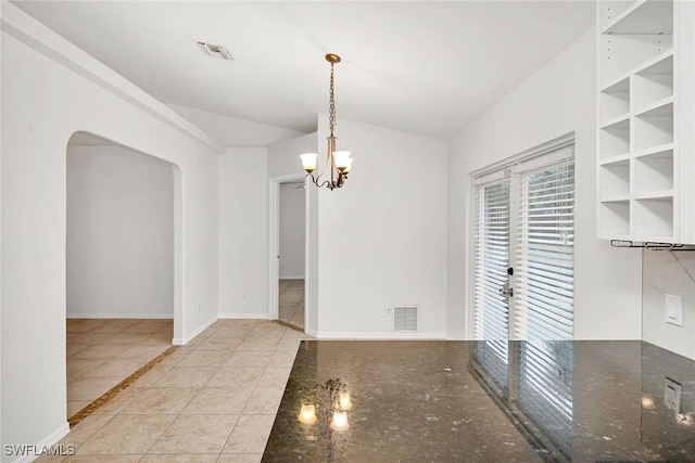 unfurnished dining area featuring light tile patterned flooring and a notable chandelier