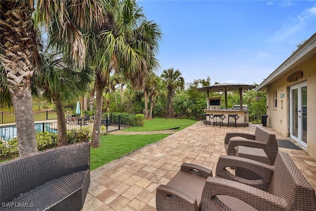 view of patio with a bar, a fenced in pool, and a gazebo