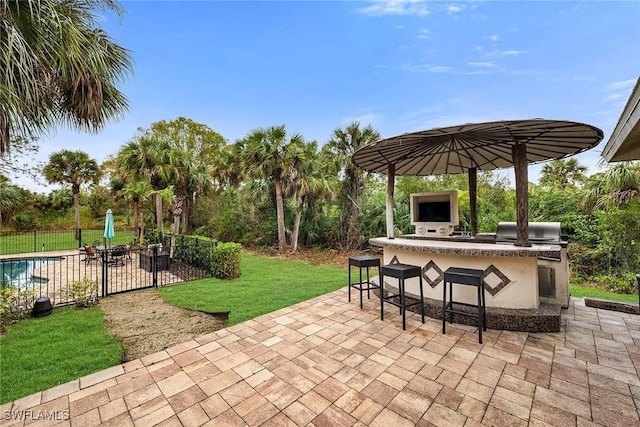 view of patio featuring an outdoor kitchen, exterior bar, and area for grilling