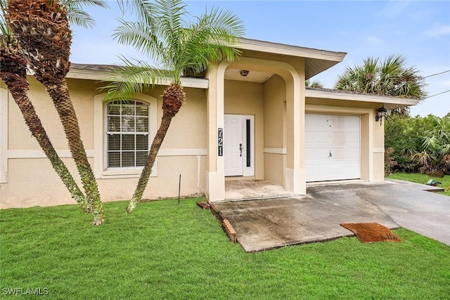 entrance to property featuring a garage and a yard