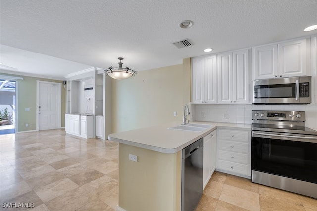 kitchen with pendant lighting, sink, white cabinetry, stainless steel appliances, and kitchen peninsula