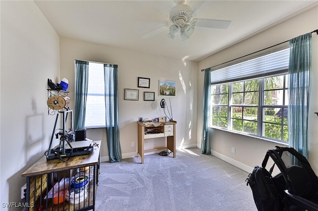 carpeted office space with ceiling fan