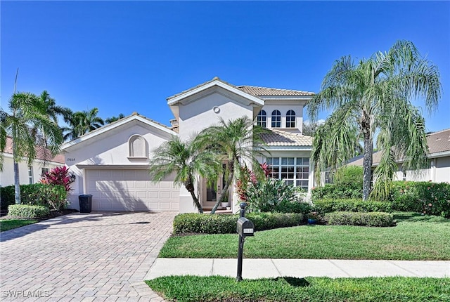 mediterranean / spanish house with a garage and a front yard