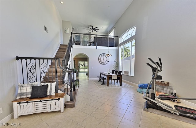 tiled foyer entrance with a towering ceiling and ceiling fan