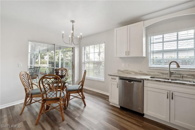 kitchen with sink, dishwasher, white cabinetry, light stone counters, and decorative light fixtures