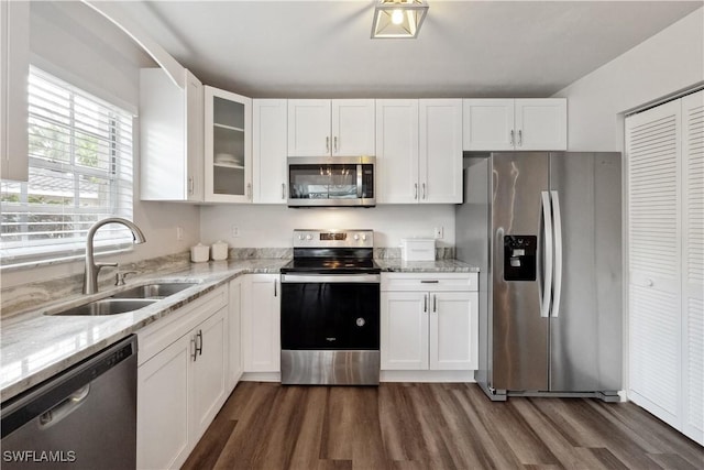 kitchen with white cabinetry, appliances with stainless steel finishes, sink, and light stone counters