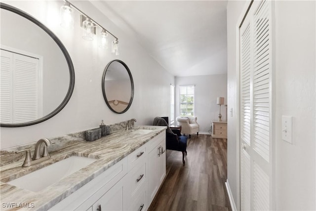 bathroom featuring vanity, wood-type flooring, and vaulted ceiling