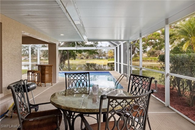 sunroom featuring a water view