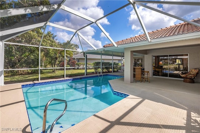 view of pool featuring exterior bar, a patio, and a lanai