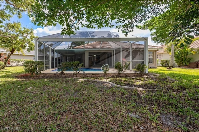 back of house with a yard and glass enclosure