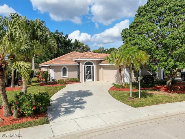 mediterranean / spanish-style house with a garage and a front lawn