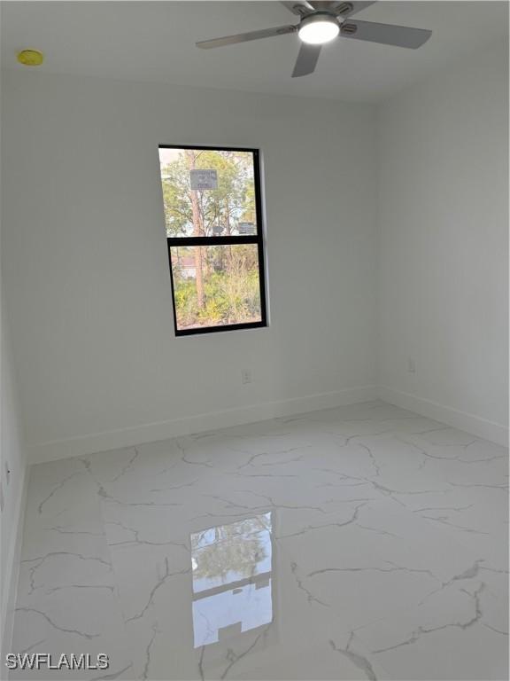 empty room featuring baseboards and marble finish floor