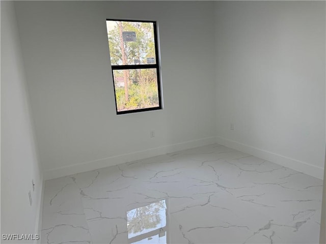 spare room with baseboards and marble finish floor