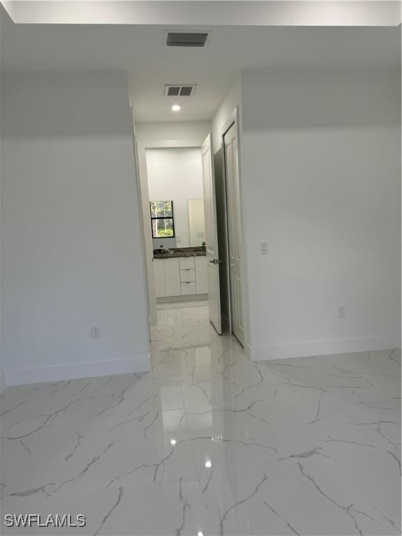 empty room with visible vents, marble finish floor, and baseboards